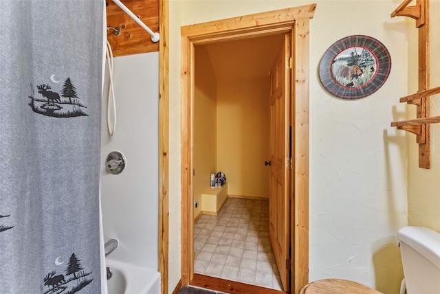 bathroom with shower / bath combination with curtain and toilet