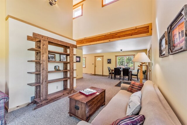 living room with carpet, a towering ceiling, and beamed ceiling