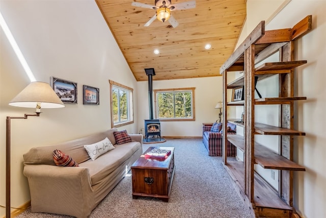 carpeted living room with ceiling fan, a wood stove, high vaulted ceiling, and wooden ceiling