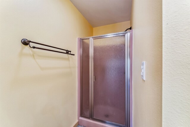 bathroom featuring a shower with shower door