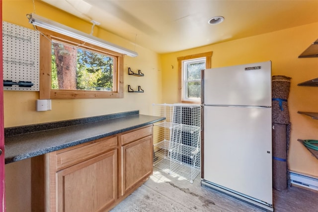 kitchen with white fridge and a baseboard heating unit