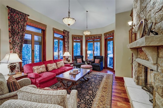 living room featuring a stone fireplace and hardwood / wood-style flooring