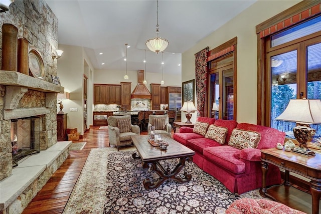 living room featuring hardwood / wood-style flooring, a stone fireplace, and french doors