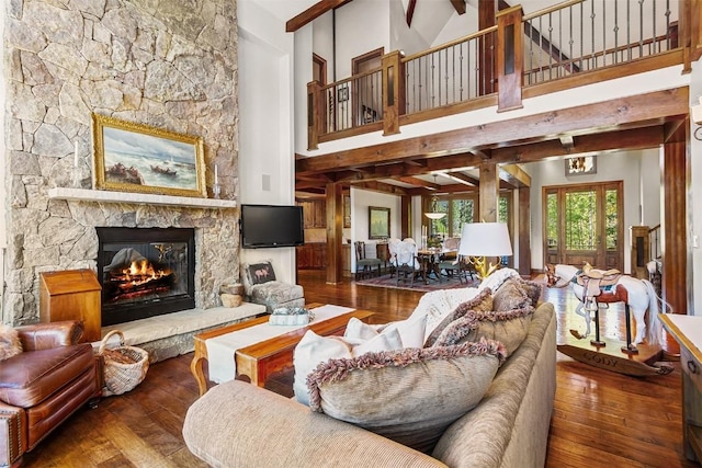 living room with a fireplace, beam ceiling, and dark hardwood / wood-style flooring