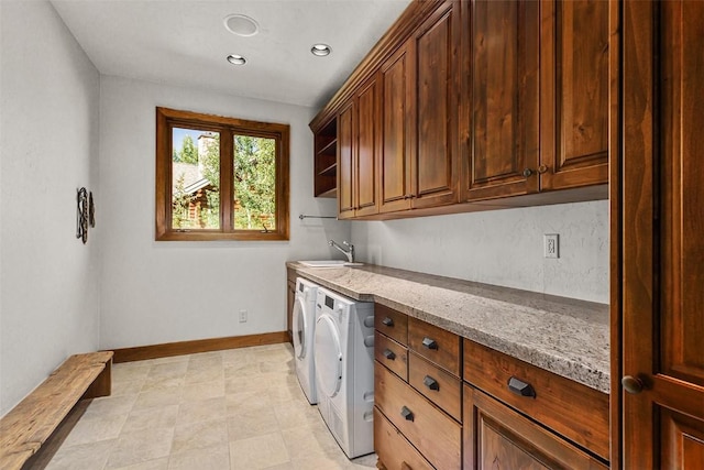 laundry room featuring cabinets, separate washer and dryer, and sink