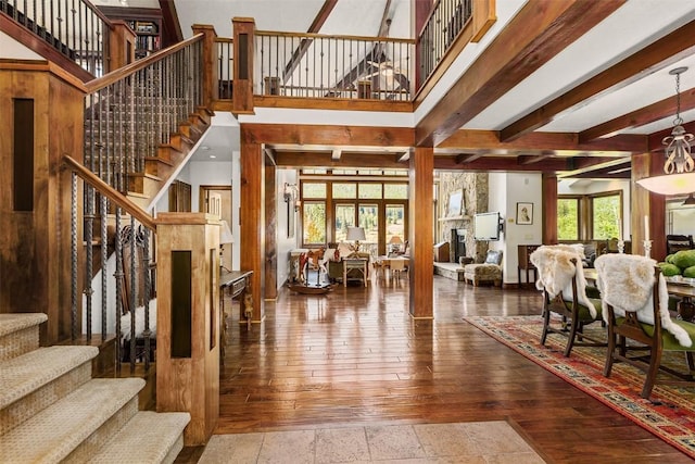 interior space with beamed ceiling, hardwood / wood-style flooring, ornate columns, and plenty of natural light