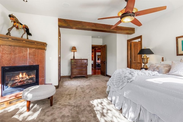 carpeted bedroom featuring beam ceiling, a tiled fireplace, and ceiling fan