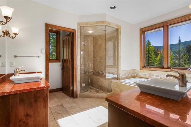 bathroom featuring tile patterned flooring, vanity, an inviting chandelier, and an enclosed shower