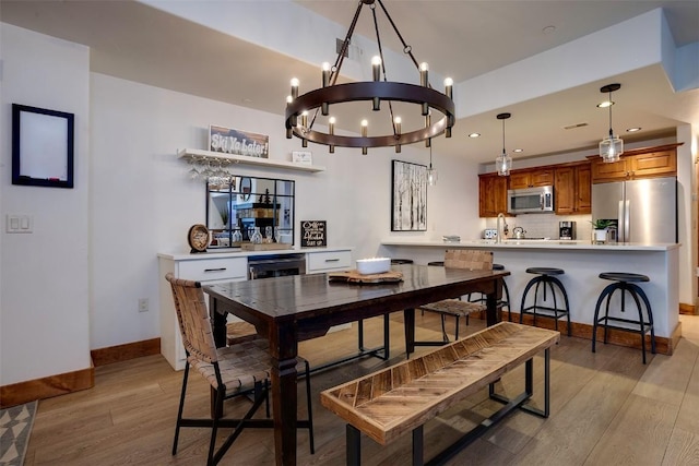 dining space featuring wine cooler and light hardwood / wood-style flooring