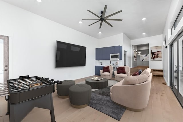 living room featuring ceiling fan and light hardwood / wood-style flooring