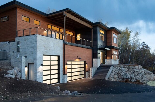 view of home's exterior with a garage, a balcony, and central AC