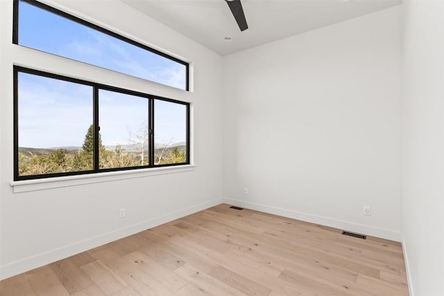 empty room with light wood-type flooring and ceiling fan