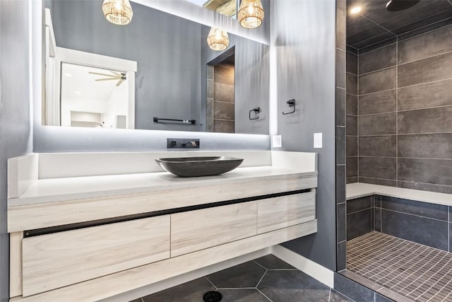 bathroom featuring a tile shower, ceiling fan, tile patterned flooring, and vanity