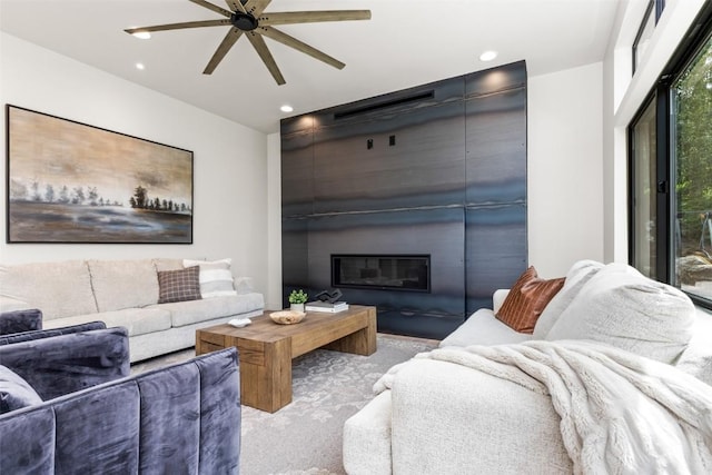 living room with a large fireplace and ceiling fan