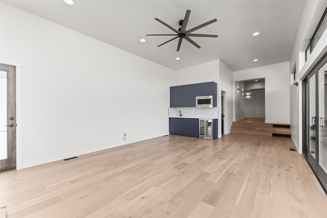 unfurnished living room featuring ceiling fan and light hardwood / wood-style flooring