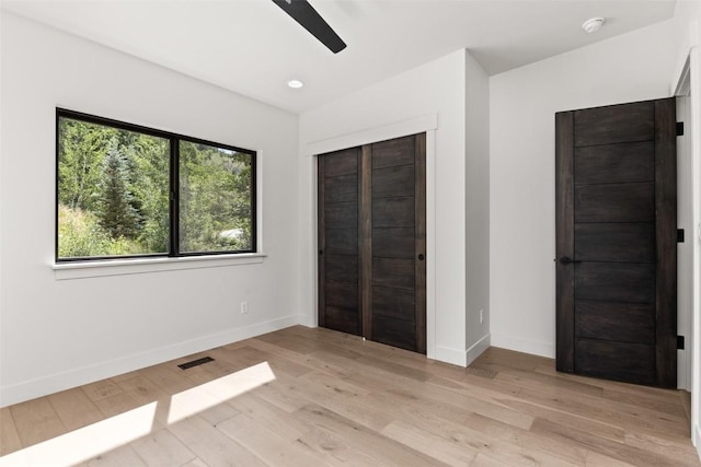 unfurnished bedroom featuring ceiling fan, a closet, and light hardwood / wood-style flooring