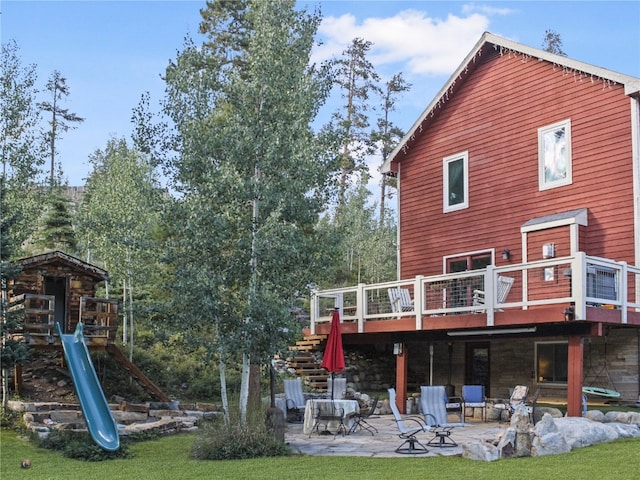 back of house with a wooden deck, stairs, and a patio