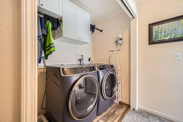 washroom featuring washer and dryer, baseboards, cabinet space, and ornamental molding