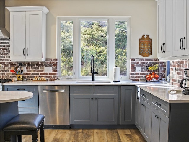 kitchen with dishwasher, gray cabinets, a wealth of natural light, and a sink