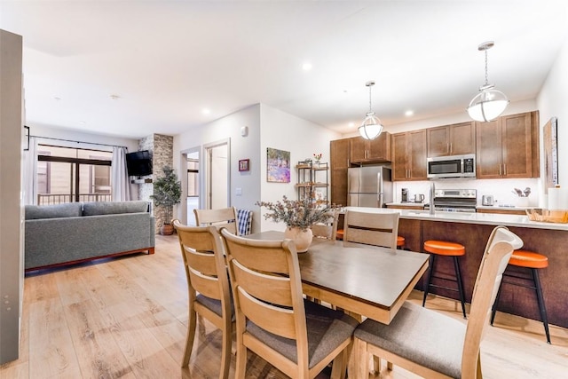 dining space with sink and light wood-type flooring