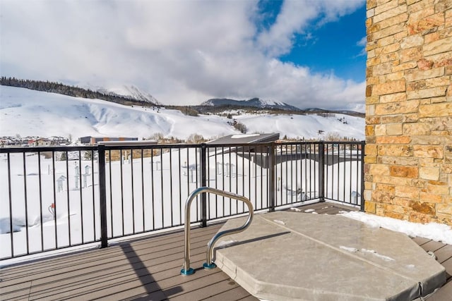 snow covered deck with a mountain view