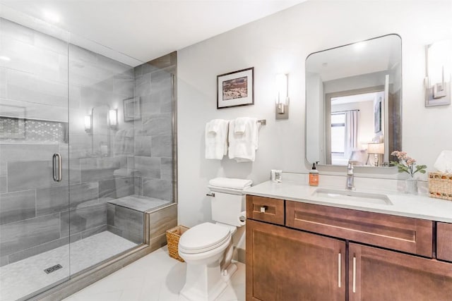 bathroom with a shower with door, vanity, tile patterned flooring, and toilet