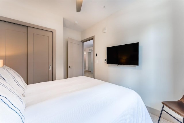 carpeted bedroom with ceiling fan and a closet