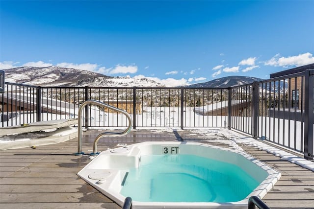 snow covered deck with a mountain view