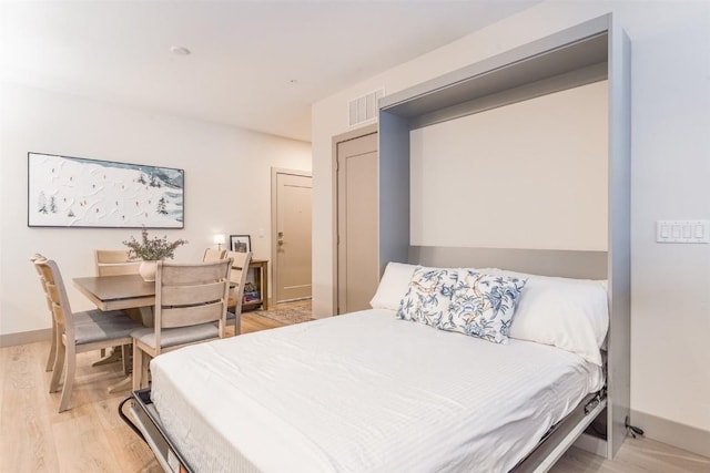 bedroom with light wood-type flooring and a closet