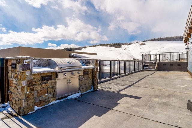 snow covered patio featuring grilling area