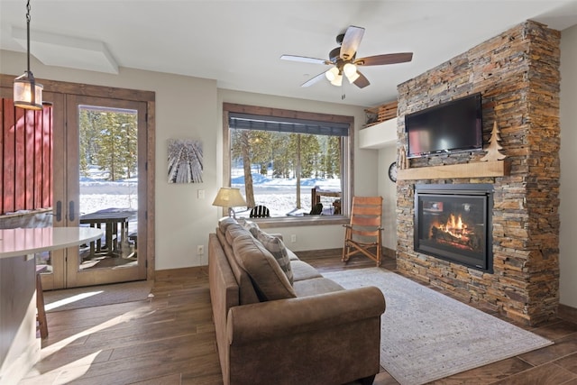 living room with baseboards, a fireplace, wood finished floors, and a healthy amount of sunlight