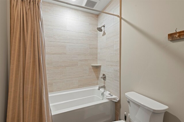 bathroom with toilet, visible vents, and shower / bath combo with shower curtain