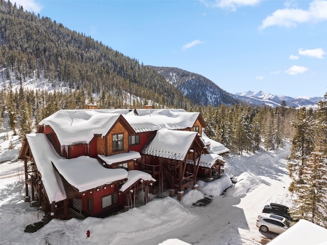 snowy aerial view with a forest view and a mountain view