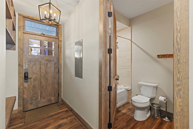 foyer featuring dark wood-style floors, electric panel, baseboards, and an inviting chandelier