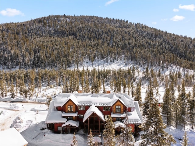 snowy aerial view with a wooded view