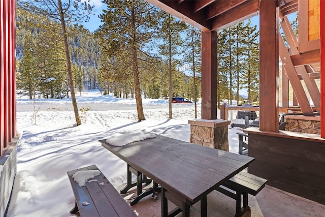 snow covered patio featuring outdoor dining area