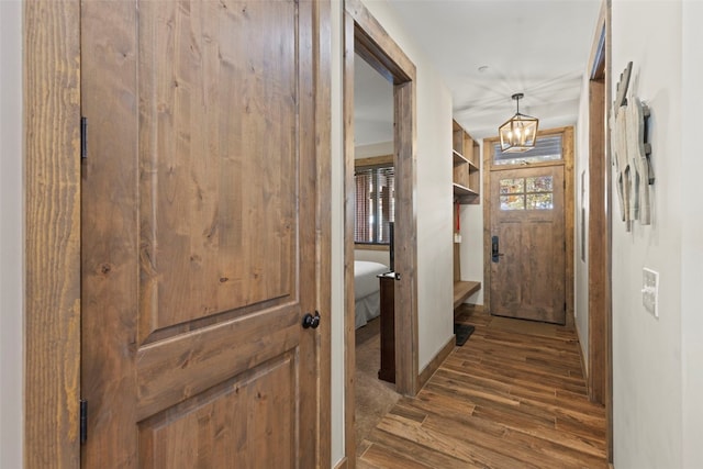 corridor with a notable chandelier and wood finished floors