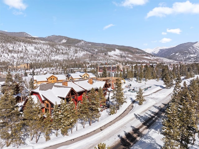 snowy aerial view featuring a residential view and a mountain view