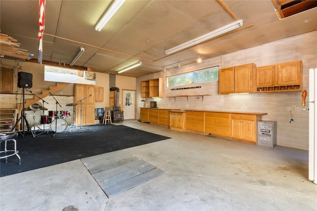 garage featuring a wood stove and white fridge