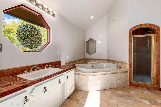 bathroom with vanity, separate shower and tub, and lofted ceiling