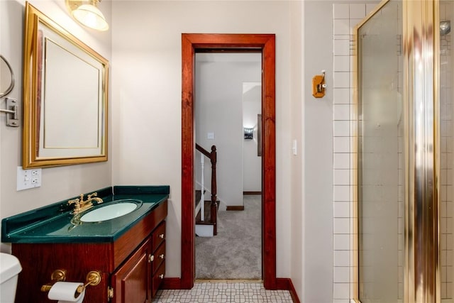 bathroom with a shower with door, vanity, and toilet