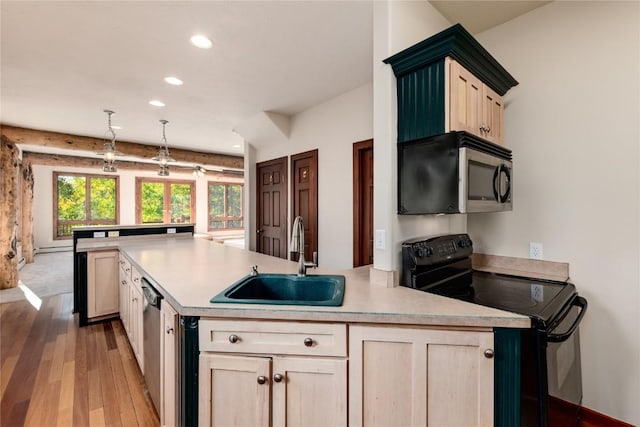 kitchen featuring appliances with stainless steel finishes, decorative light fixtures, light brown cabinetry, and sink