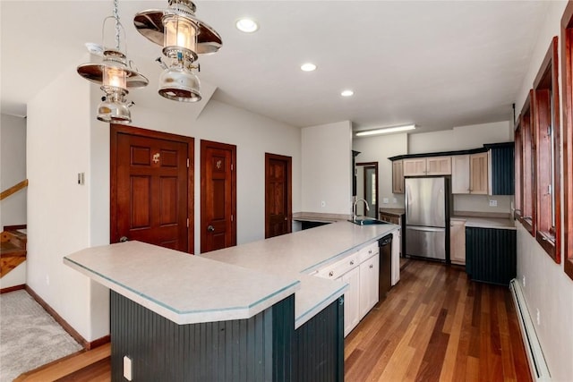 kitchen featuring stainless steel refrigerator, a baseboard radiator, black dishwasher, dark hardwood / wood-style flooring, and a breakfast bar area