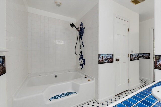 bathroom with tiled shower / bath combo and tile patterned floors