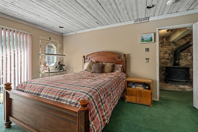 bedroom featuring dark colored carpet, a wood stove, crown molding, and wood ceiling