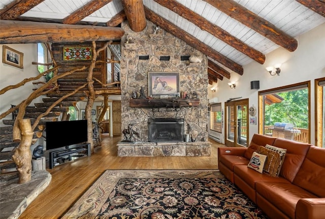 living room featuring hardwood / wood-style floors, beam ceiling, a fireplace, and high vaulted ceiling