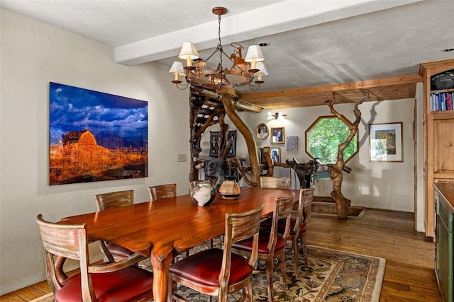 dining space with beam ceiling, a notable chandelier, and hardwood / wood-style floors