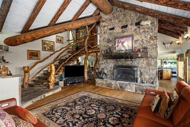 living room featuring beamed ceiling, high vaulted ceiling, a fireplace, wood ceiling, and hardwood / wood-style flooring