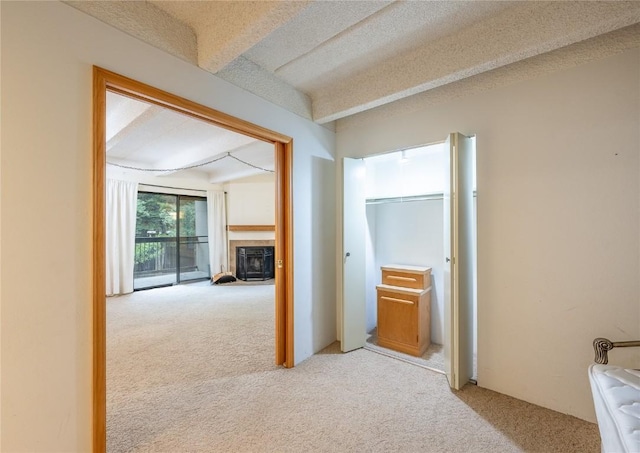 hall featuring beam ceiling and light carpet