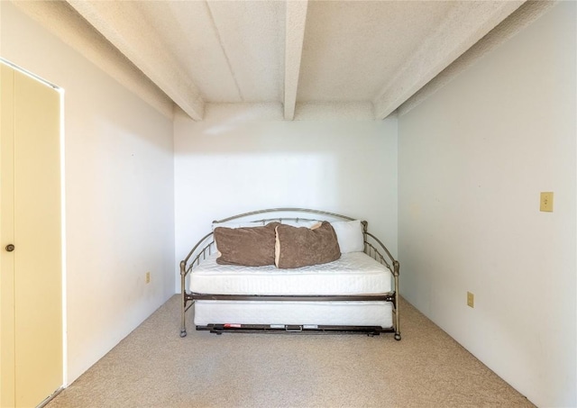 carpeted bedroom featuring beamed ceiling